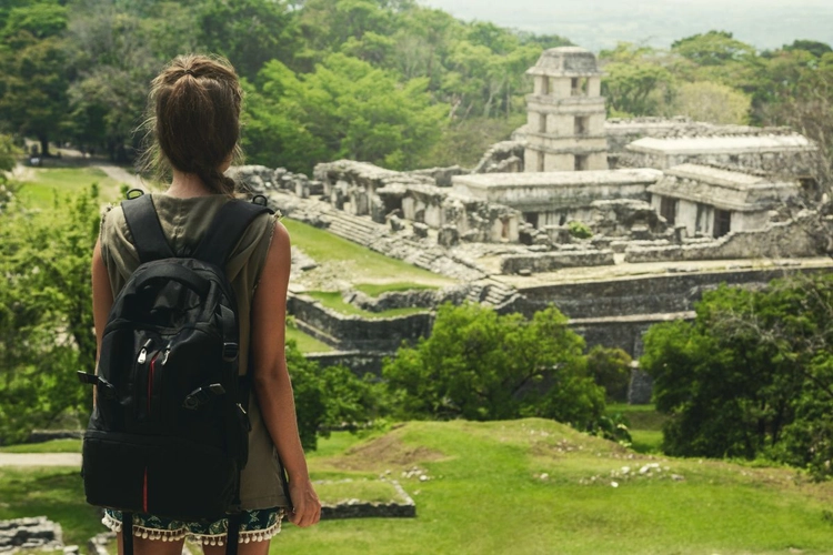 Backpackerin blickt auf Maya Ruinen