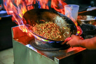 Wok-Pfanne über offener Flamme
