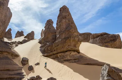 Frau geht eine Düne in der algerischen Wüste hinunter