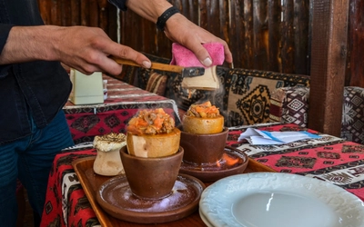 Nationales türkisches Gericht namens Testi-Kebab, das in einem Tontopf über Feuer gekocht wird, der vor dem Verzehr zerbrochen wird.